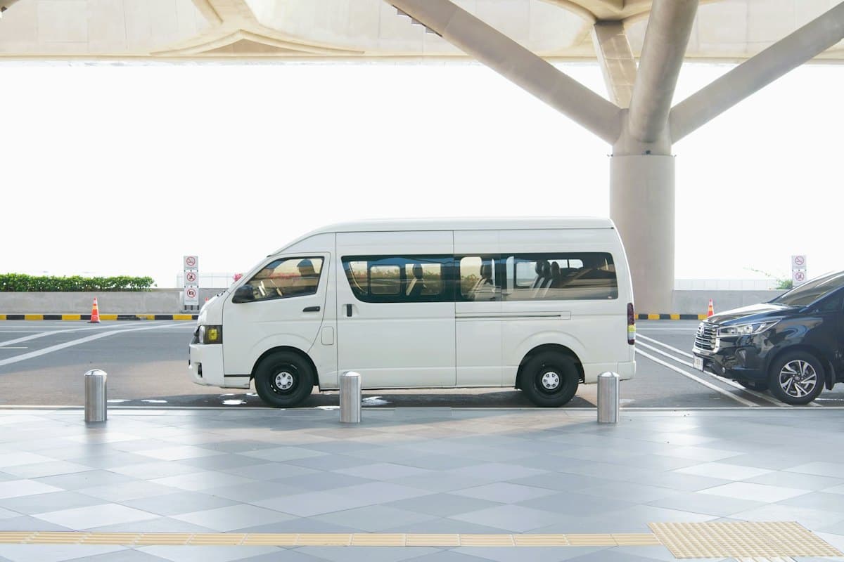 White high-roof KDH passenger van at an airport terminal